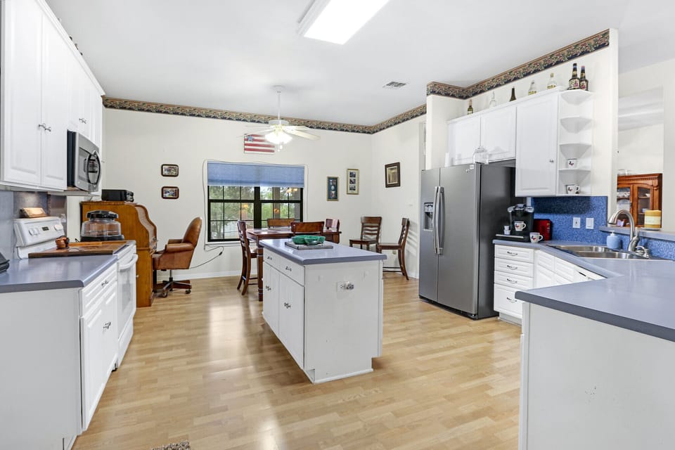 Kitchen is equipped with a refrigerator, microwave, oven, stove, and coffee maker