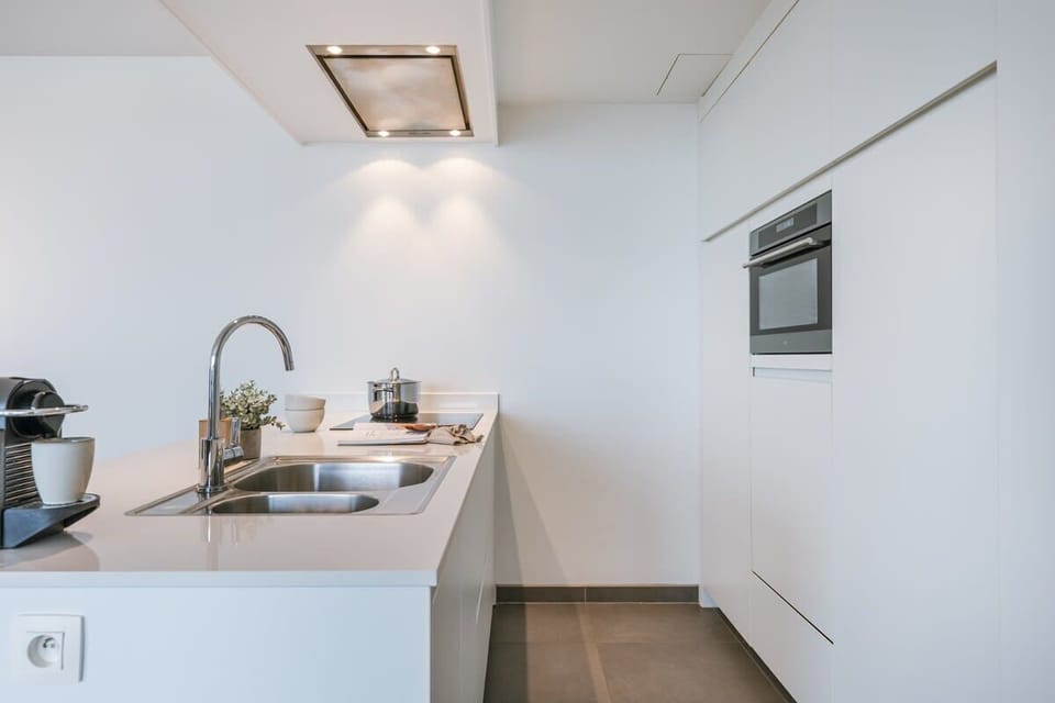 Bright white kitchen — stylish, compact, everything within reach.
