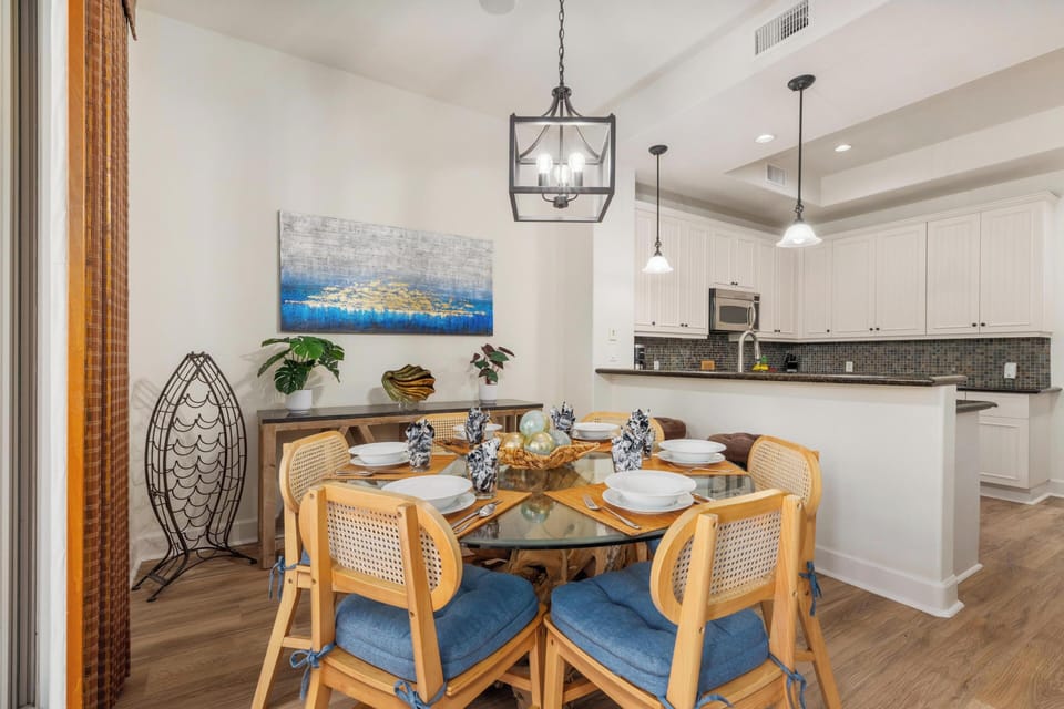 Gather around your beautifully appointed dining space, where coastal artwork and elegant lighting create the perfect setting for memorable meals together.