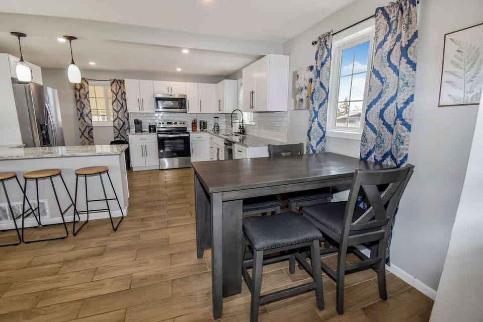 The kitchen boasts modern appliances and plenty of counter space, complemented by a convenient bar counter. Adjacent to it is a cozy 4-seater dining area, perfect for enjoying meals or gathering with friends and family.