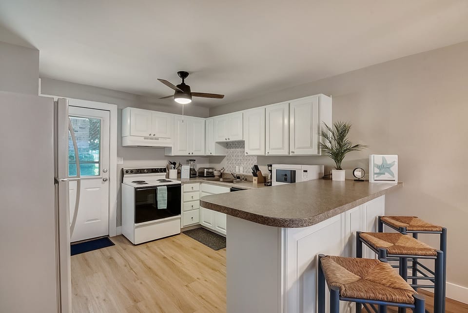 Your fully equipped kitchen features modern appliances, granite counters, and a breakfast bar perfect for morning coffee or casual meals.