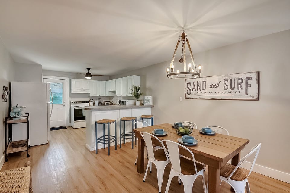 Your beach-themed retreat features an open kitchen perfect for family meals and coastal conversations around the farmhouse dining table.