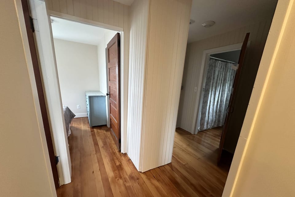 Upstairs hallway with view into one of the bedrooms and the bathroom