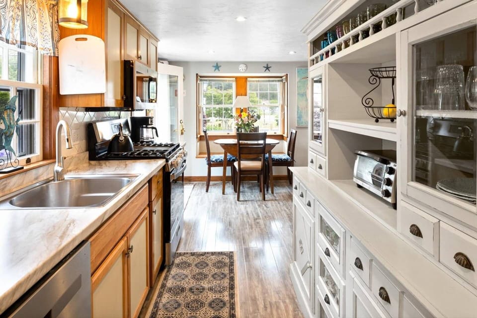 Modern kitchen with stove, oven, microwave, tea kettle, toaster oven, coffee maker, and dishwasher