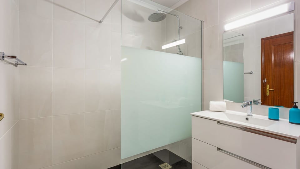 Refresh yourself in the sleek, modern bathroom featuring a spacious walk-in shower with a rainfall head for a spa-like experience.
#Bathroom #WalkInShower #LovelyStay