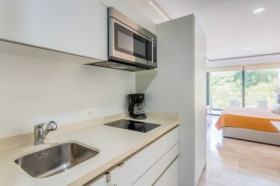 Kitchenette with a coffee maker, microwave, and electric stovetop.