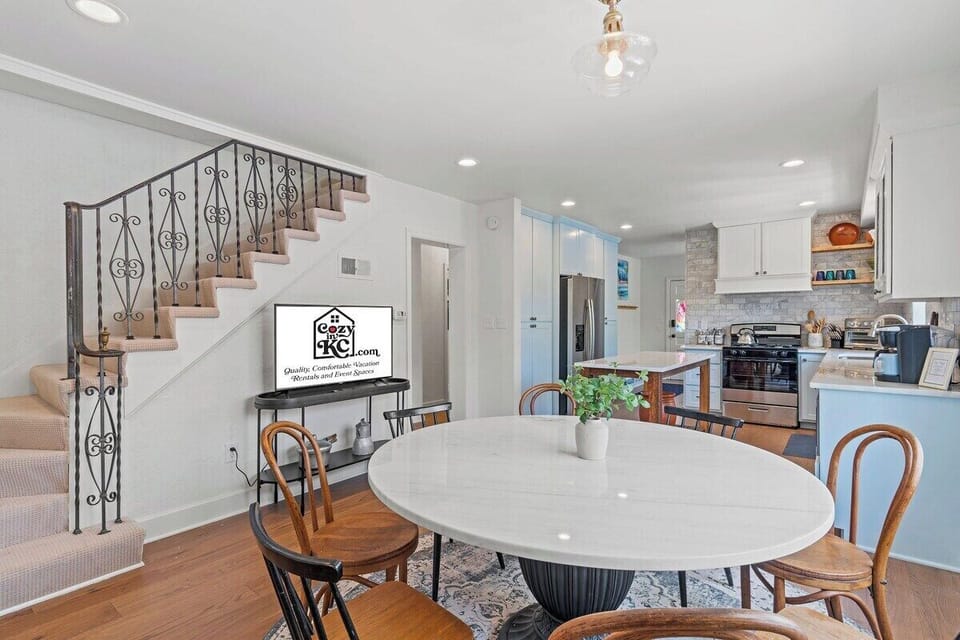 Bright dining space with modern lighting, easy kitchen access, and a Smart TV just steps away—perfect for shared meals, game nights, or relaxing together during your stay.