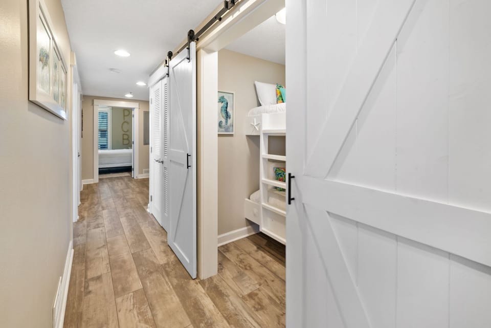 Your private hallway features beautiful hardwood floors, custom built-in storage, and a charming sliding barn door leading to the bedroom.