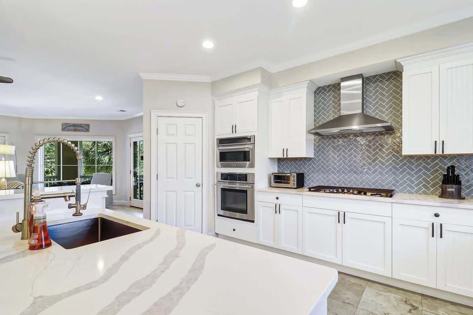 Bright, beautifully designed kitchen featuring sleek countertops, modern appliances, and an open layout that flows seamlessly into the living space - perfect for gathering and entertaining.