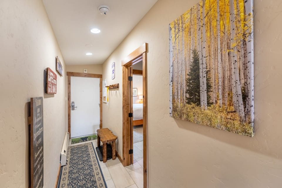 Step into your welcoming hallway where warm wood accents and inspiring mountain artwork create a cozy, homey atmosphere from the moment you arrive.