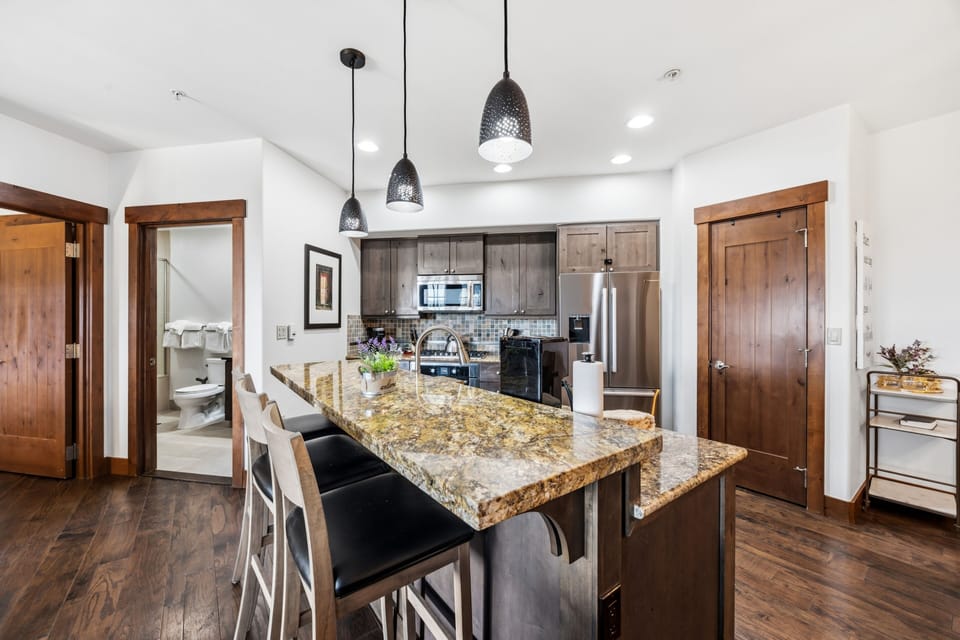 Kitchen island — three pendants, granite, full cooking inventory.
