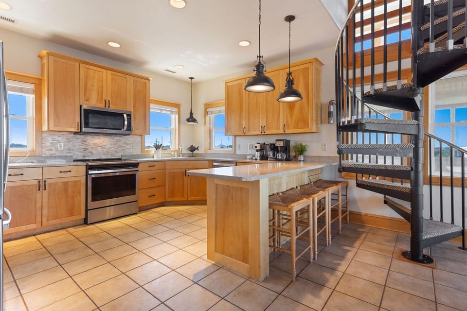 The fully equipped kitchen offers modern appliances and plenty of space for preparing coastal-inspired meals.