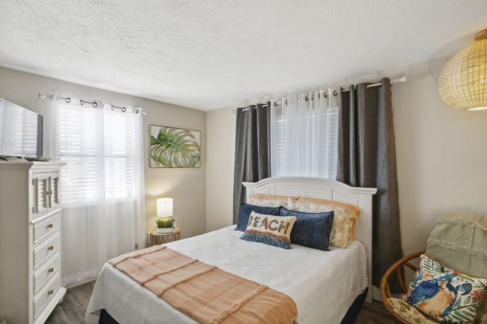 Initial entrance into the spacious bohemian bedroom decorated with tropical artwork.