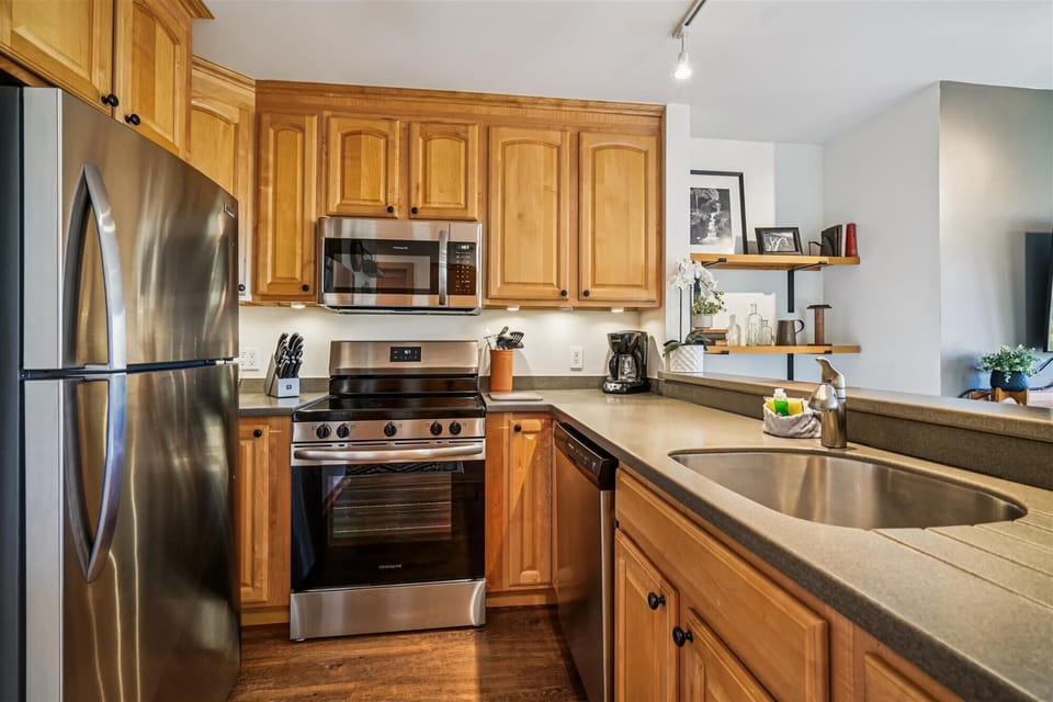 Stainless steel appliances, full-size range, microwave, and dishwasher with ample counter space for easy meal prep.
