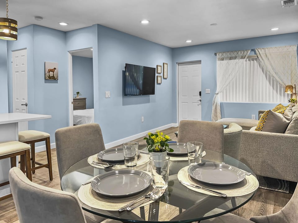 Dining and living area with round dining table, mounted flat-screen TV, and comfortable seating