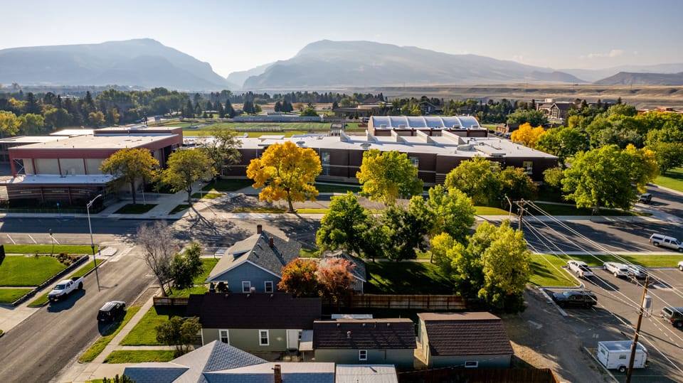 Aerial view of house looking over Cody High School- with Cedar and Rattlesnake Mountains in the distance