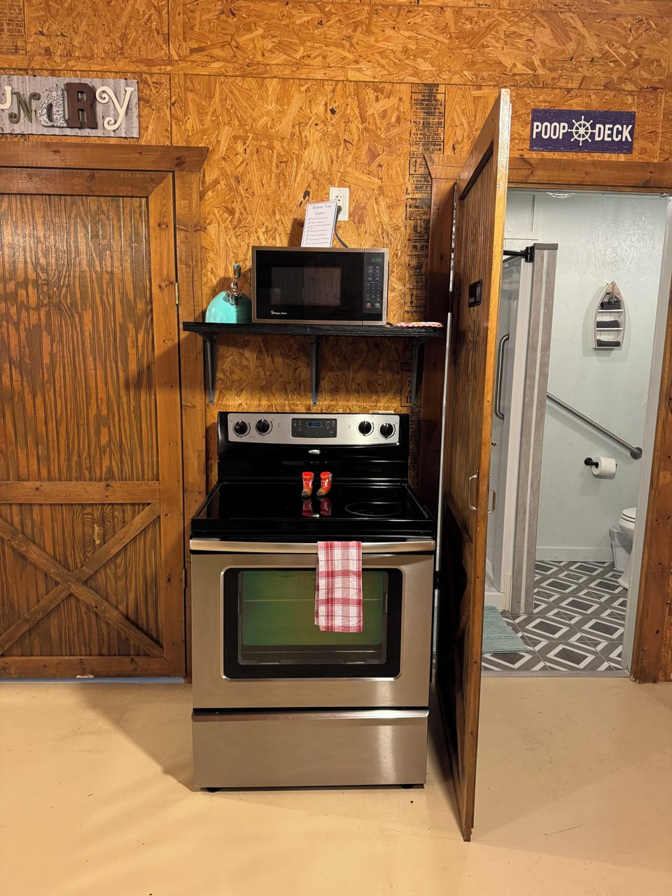 Glass top stove with oven, microwave is above the stove.