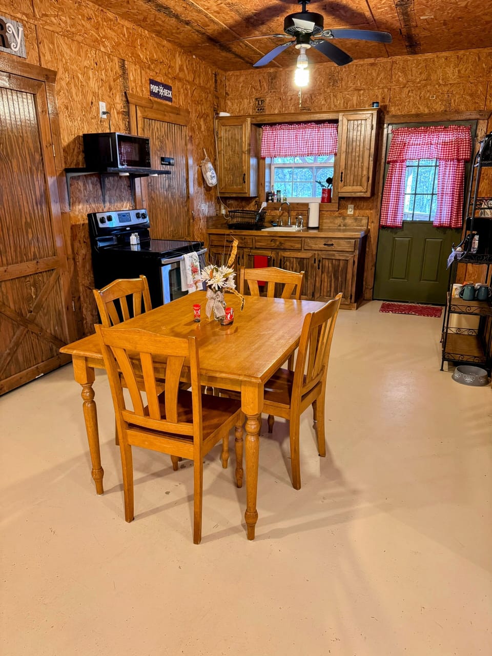 Kitchen table, stove, oven and ceiling fan.