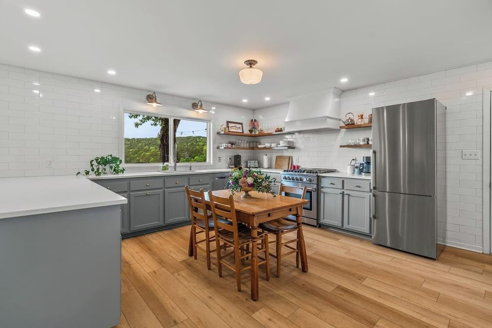Full kitchen with breakfast table and window overlooking the deck and mountains.