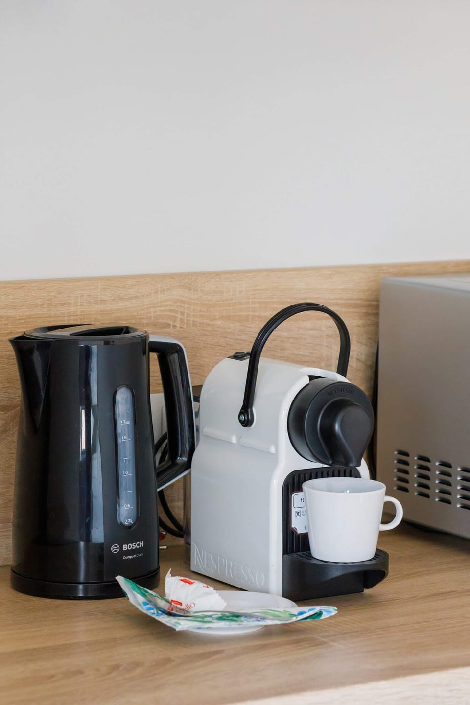 A close-up of a kitchen corner with a built-in oven, wooden flooring, and minimalist decor.