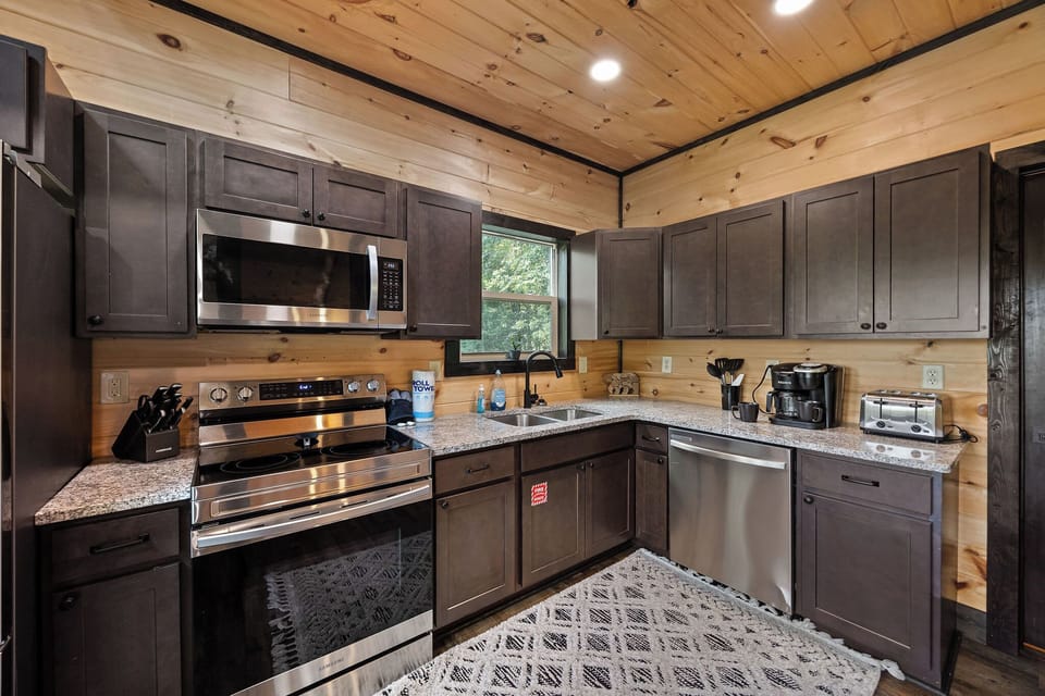 Cookin’ made easy with full kitchen with shiny stainless steel appliances, cozy wood paneling, and plenty of counter space for gatherin’ and chattin’ while supper’s on.