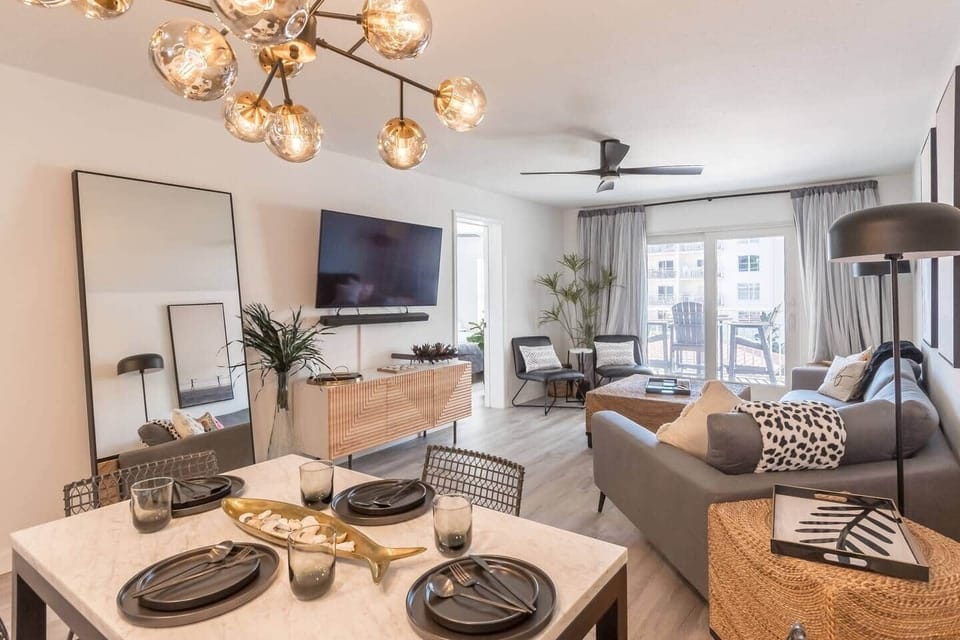 Unwind in Elegance: Where Stylish Comfort Meets Seamless Entertaining. Our open floor plan living and dining area invites you to relax in luxury and dine with friends. With a spacious couch, extra chairs, and seating for six at the table and bar.