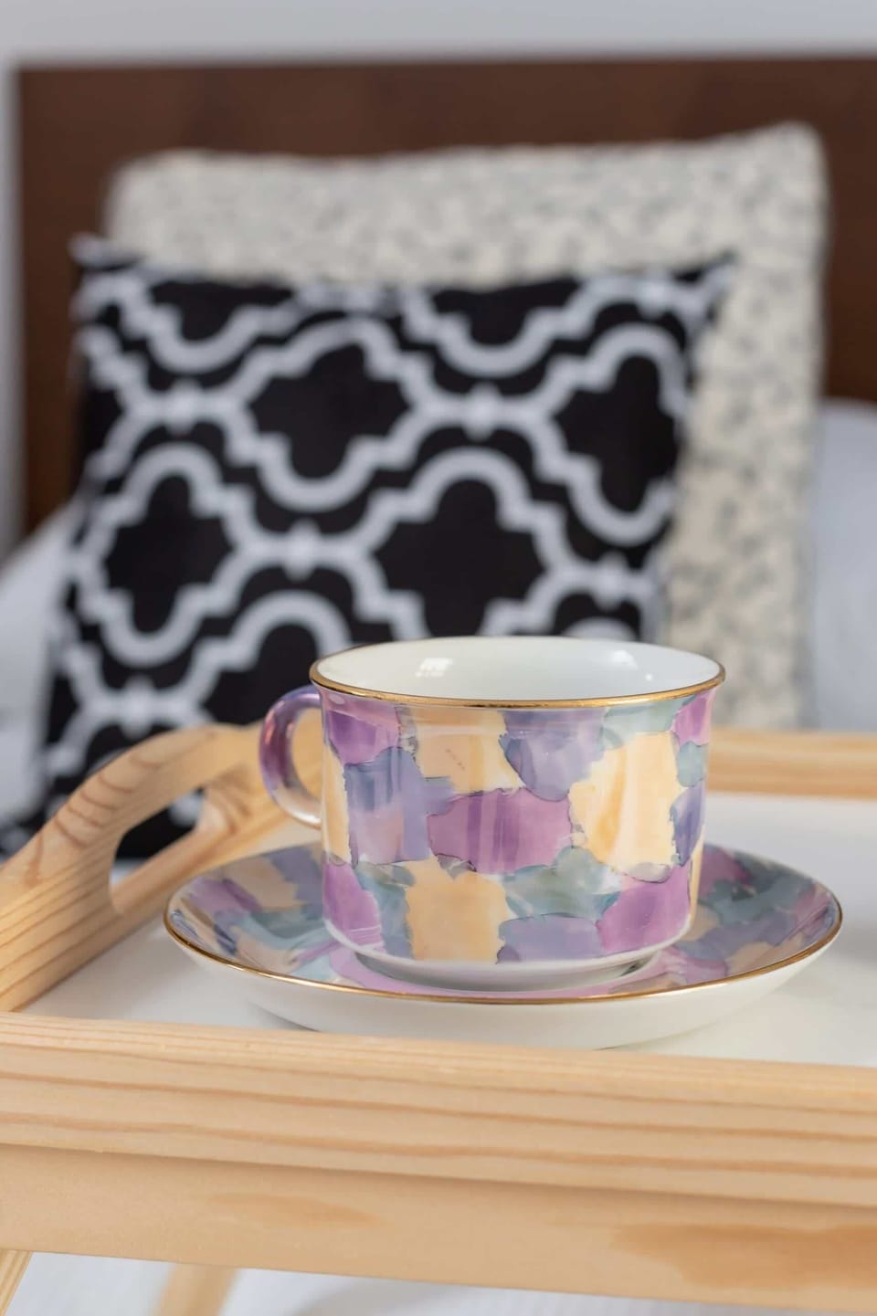 A close-up of a decorative arrangement featuring a small round table with a patterned fabric cover and a drinking glass. This small detail enhances the cozy feel of the space.