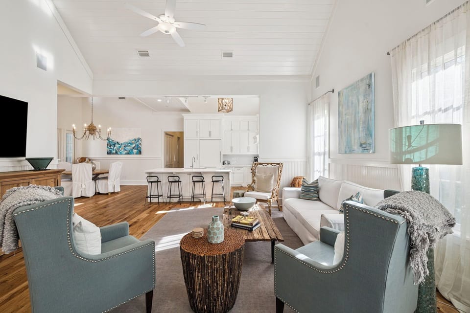 Relax in this elegant open-concept living space where coastal blues meet warm whites, creating your perfect sanctuary for unwinding after beach adventures.