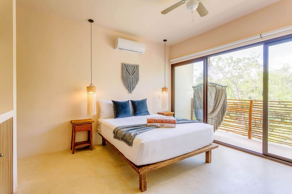 Bedroom 1 w/ queen bed, ensuite bathroom, kitchenette, Smart TV & balcony access