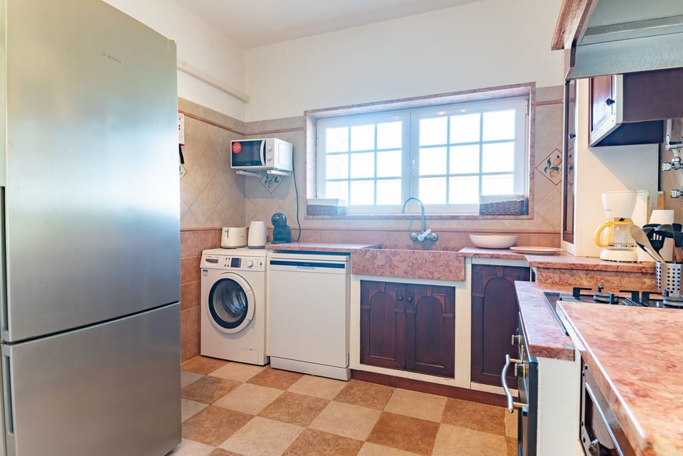 Modern kitchen with stainless steel appliances and terracotta tiling — Villa Terra Mar, holiday villa in Mafra