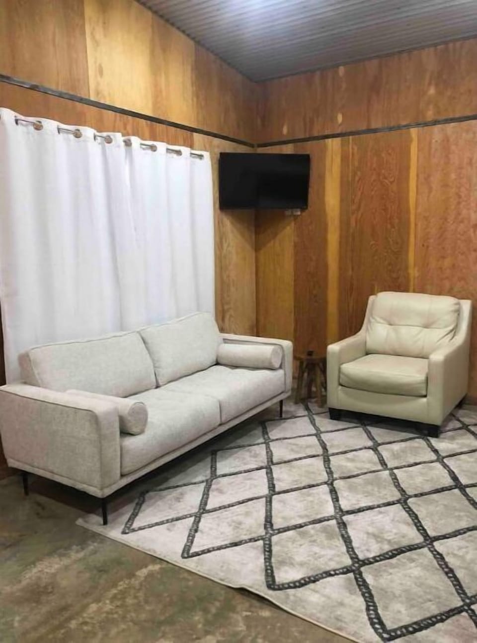 Sofa & Leather chair.  Room darkening curtains. Television w/ antenna 24 channel