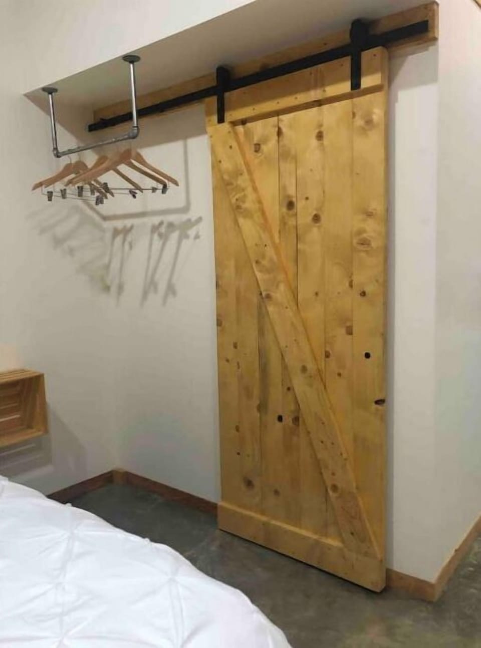 Barn door to bathroom, Hanging rack with wooden hangers.