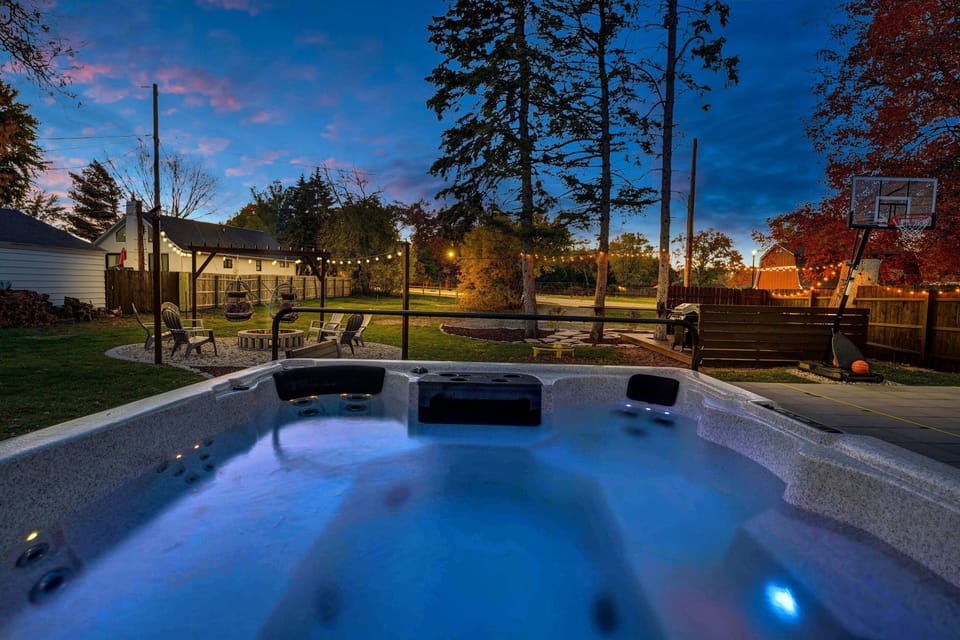The photo doesn't do the size of this hot tub justice...COMFORTABLY fits 10! Look out onto the firepit, bbq deck and basketball court while relaxing