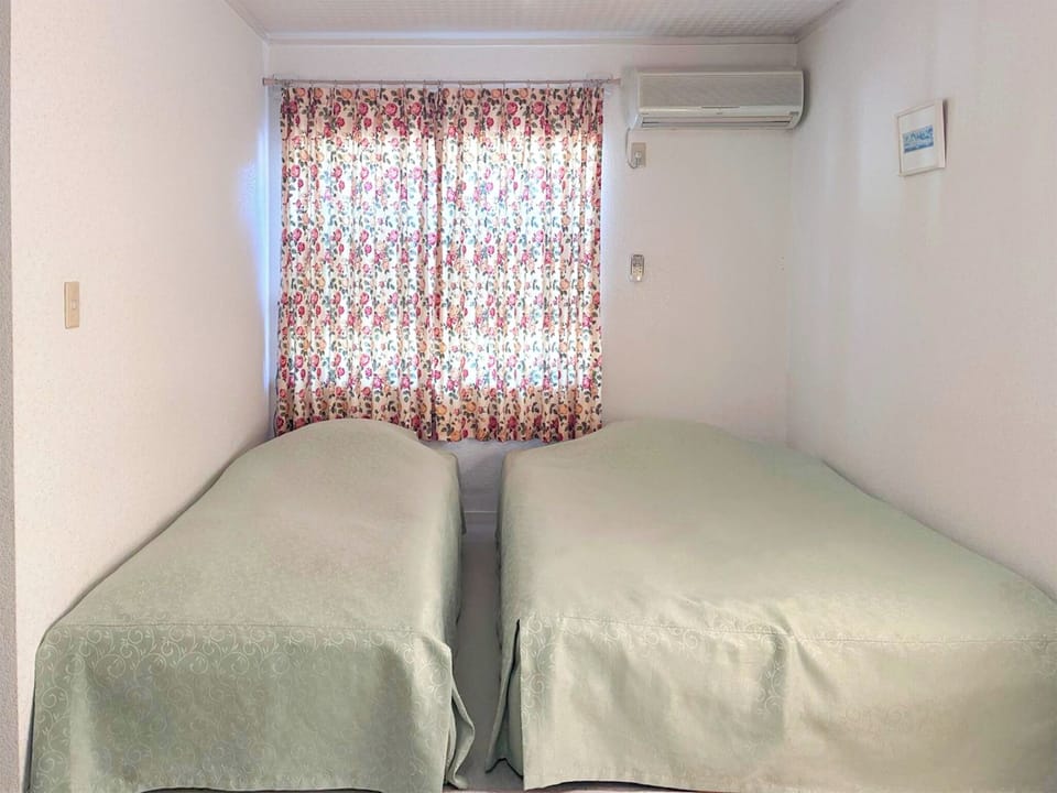 ・[Main building: Japanese-Western style room] A neat bedroom equipped with one single bed and one double bed.