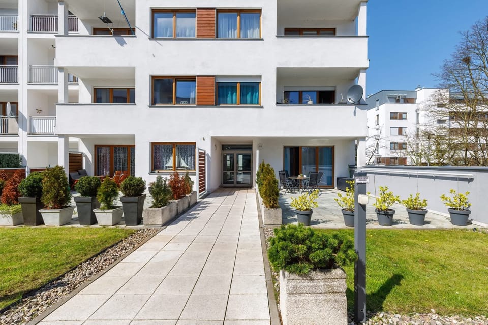 A photo of the apartment building's exterior, showcasing its modern design and landscaped surroundings.