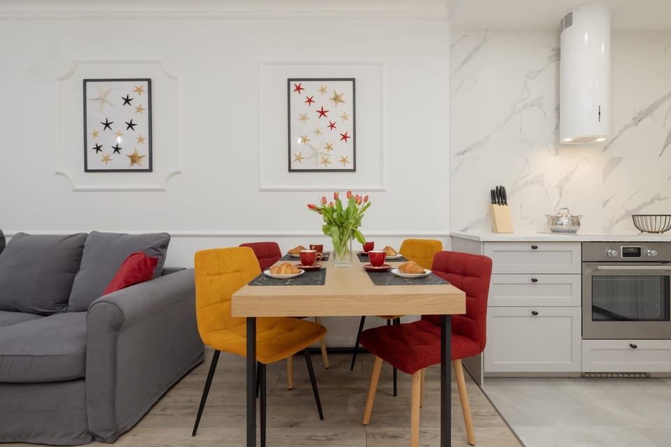 A dining area with a modern table, vibrant yellow chairs, and fresh flowers, blending comfort with a pop of color.

