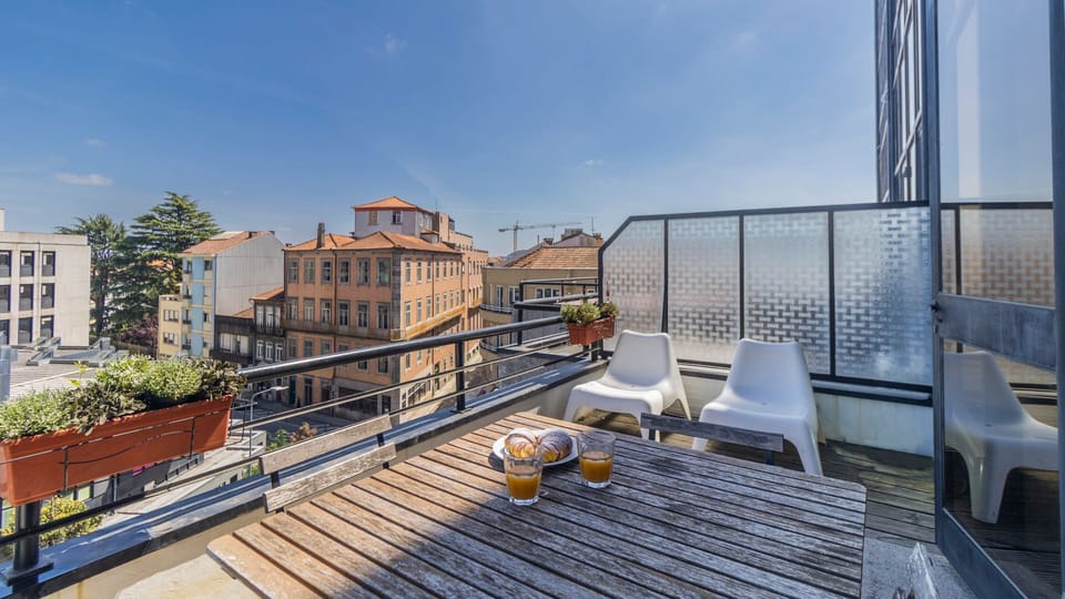 Enjoy your morning coffee or an evening drink on this charming balcony, offering lovely city views perfect for soaking up the local atmosphere. The outdoor dining setup provides an ideal spot for al fresco meals under the clear sky. #BalconyLife #CityView