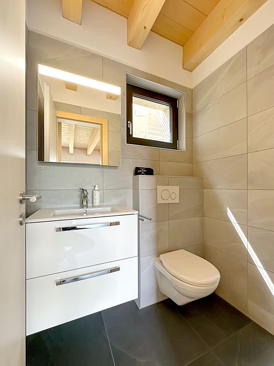 Functional guest WC with washbasin and mirror.