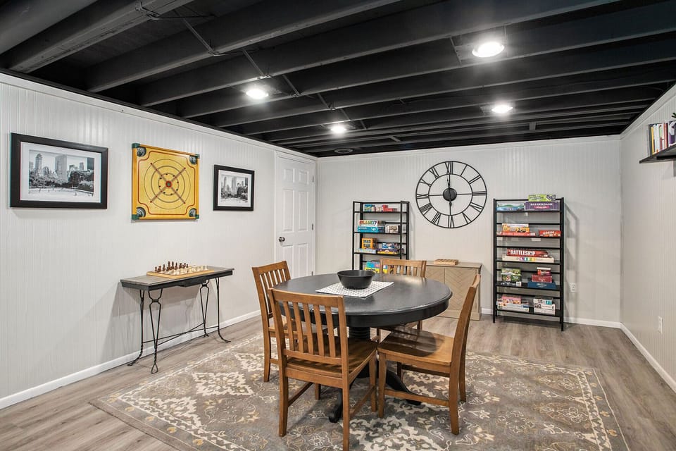 Game night ready: Table with 4 chairs, shelves full of board games for fun-filled family time.