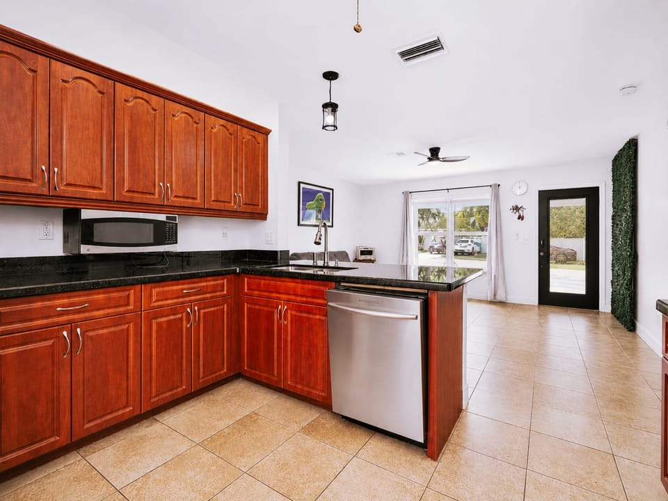 Bright open kitchen with rich wood cabinets and sleek black countertops