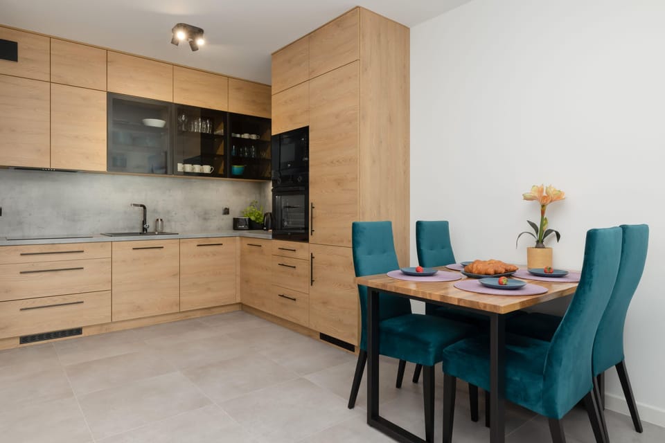 Dining area with four green chairs and a wooden table.
