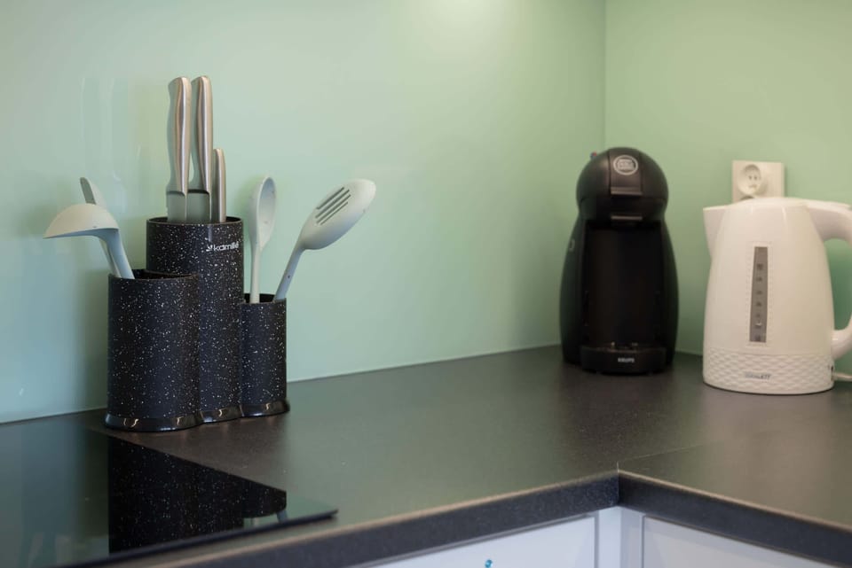 A close-up of the kitchen counter with a coffee machine, kettle, and other essential appliances for guest convenience.
