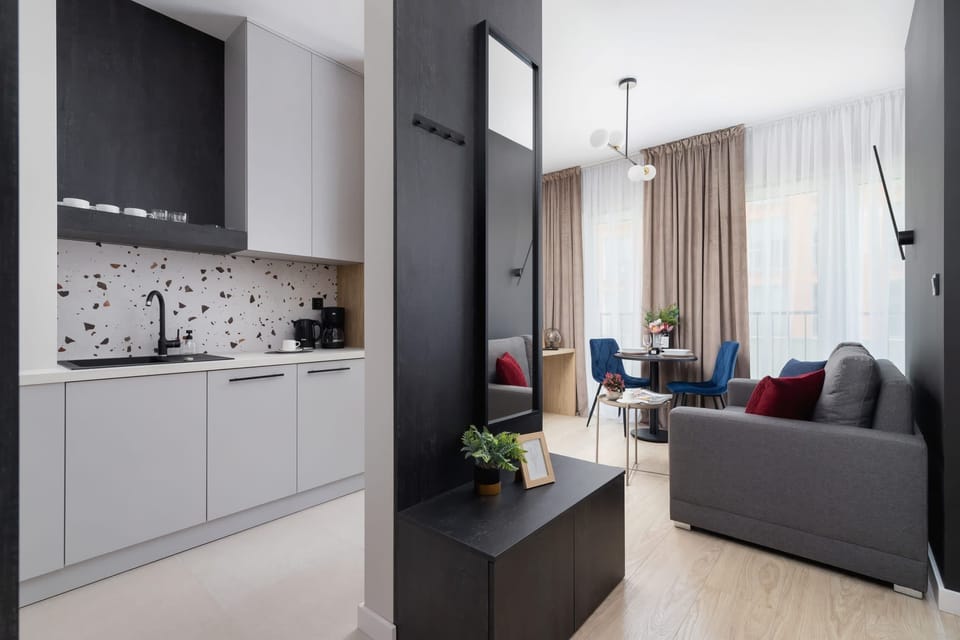 An open-plan living and kitchen area with sleek cabinetry, a dining table, and stylish furnishings.
