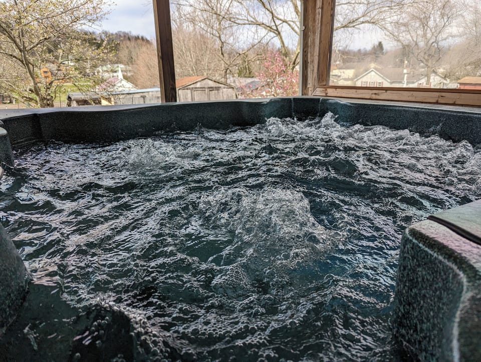 Large Hot Tub on Covered Spacious Porch. 