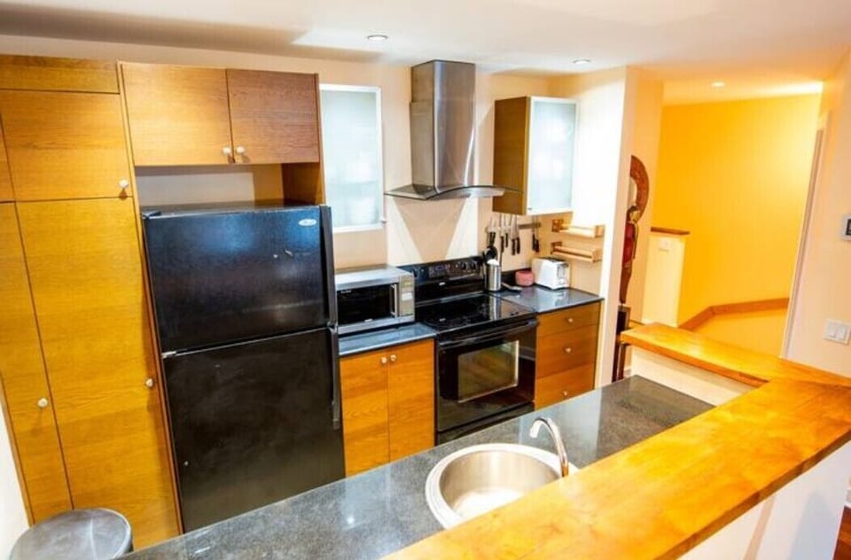 Fully equipped kitchen with teak wood bar and slate floor