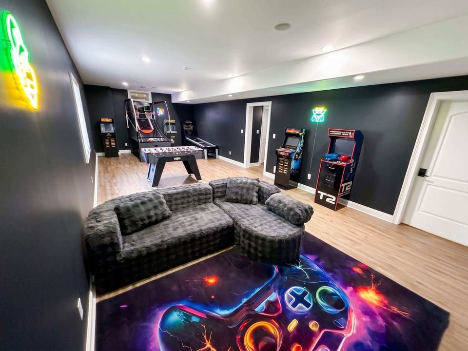 The Ultimate Game Room — An arcade-lover's dream: classic stand-up arcade cabinets (Ms. Pac-Man multi-game, Centipede, Mortal Kombat, and more), dual-hoop pop-a-shot basketball, an LED ball-roller alley, foosball, a wall-mounted gaming TV