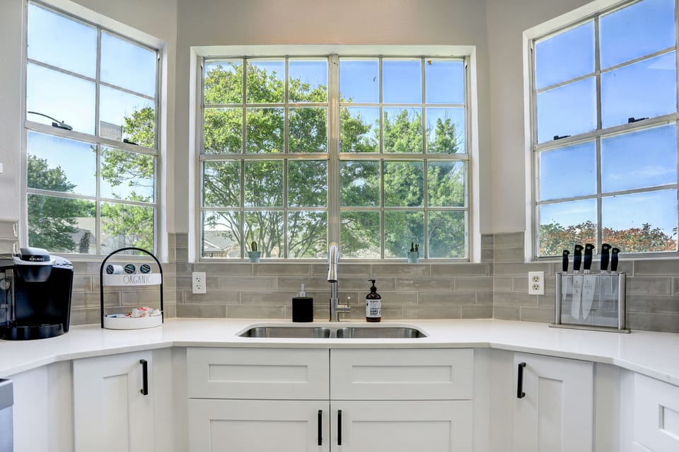 High ceiling kitchen with bay window. Curtains are provided.