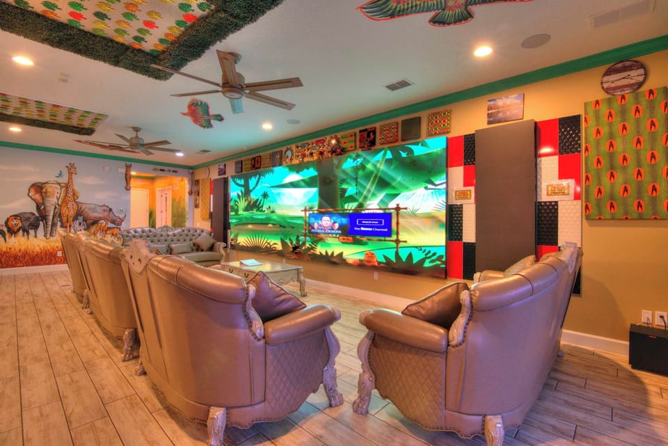 Immerse yourself in this jungle-themed game room with plush seating and a massive screen for ultimate entertainment.