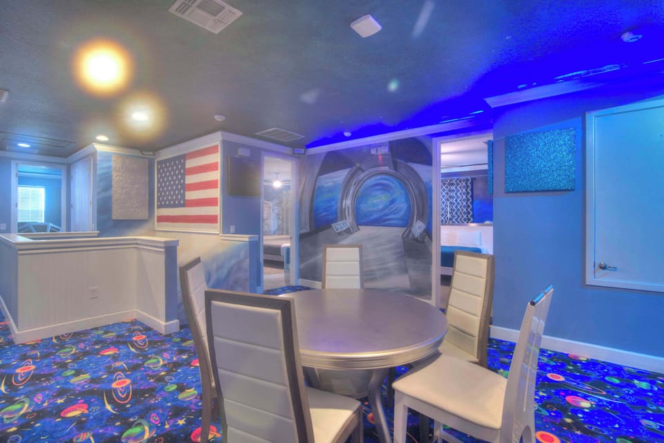 Experience a unique space-themed room with vibrant decor and cozy seating, perfect for gatherings.