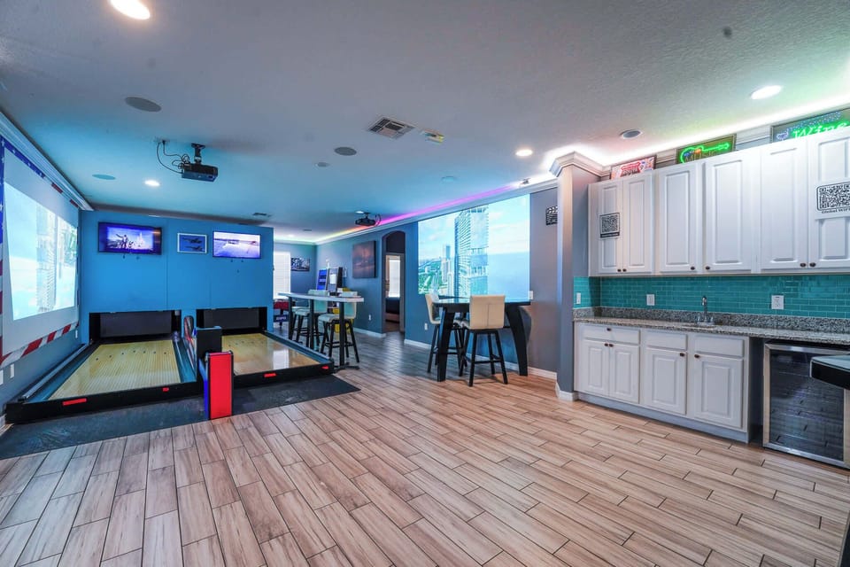 Experience endless fun in this vibrant game room with a private bowling alley and bar seating, perfect for entertaining guests.